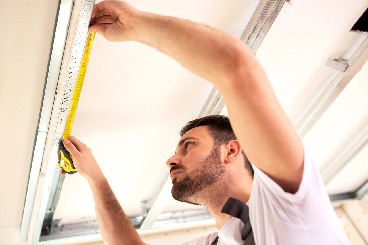 Man measuring a garage door above his head